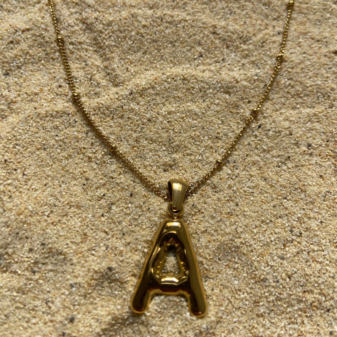 Conjunto de collar dorado Duna con charm de letra inicial de Auredune, detalle del acabado