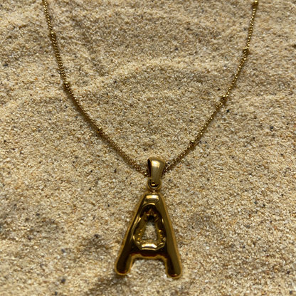 Conjunto de collar dorado Duna con charm de letra inicial de Auredune, detalle del acabado