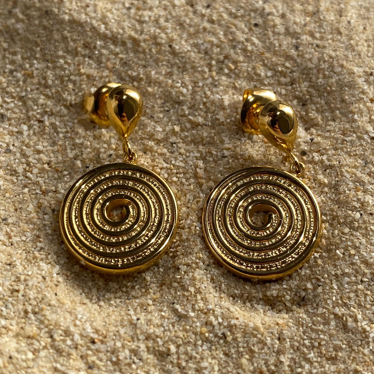 Pendientes dorados en espiral pequeños modelo Aura de Auredune, detalle del acabado