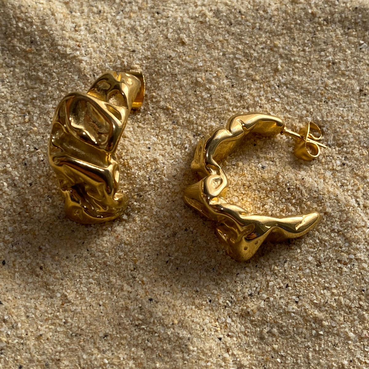 Pendientes dorados de forma irregular modelo Brisa de Auredune, detalle del acabado